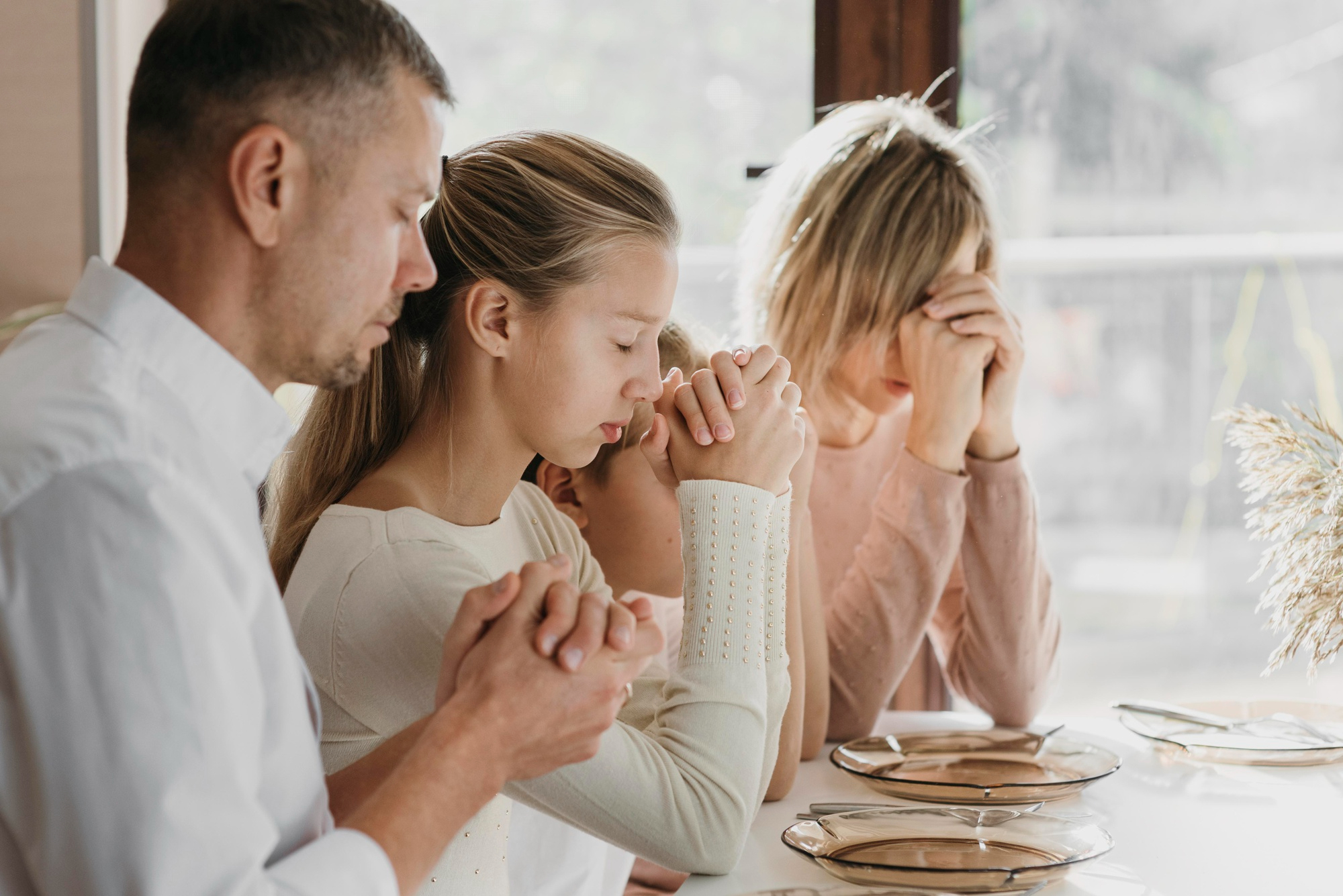 beautiful-family-praying-together-before-eating